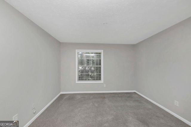 carpeted empty room with a textured ceiling