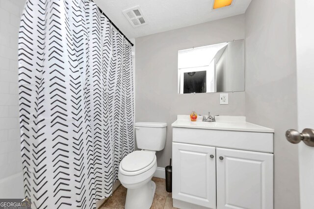 bathroom featuring tile patterned flooring, toilet, vanity, and curtained shower