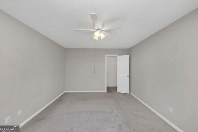 empty room featuring ceiling fan and light colored carpet