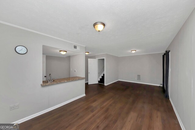 spare room featuring sink, a textured ceiling, and dark hardwood / wood-style floors