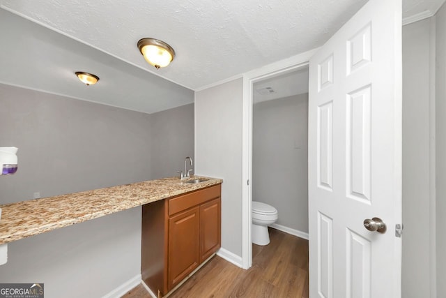 bathroom with hardwood / wood-style flooring, toilet, a textured ceiling, and vanity