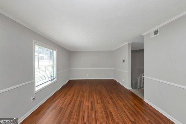 empty room featuring ornamental molding and wood-type flooring