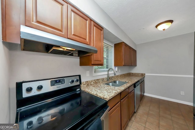 kitchen featuring sink, appliances with stainless steel finishes, light stone countertops, a textured ceiling, and light tile patterned floors