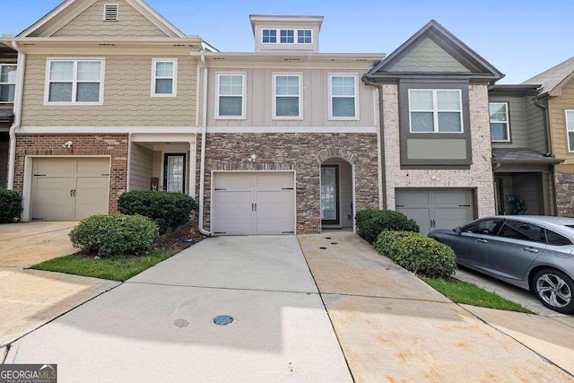 townhome / multi-family property with an attached garage, concrete driveway, and brick siding