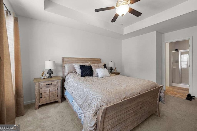 bedroom featuring a raised ceiling, a ceiling fan, and light colored carpet