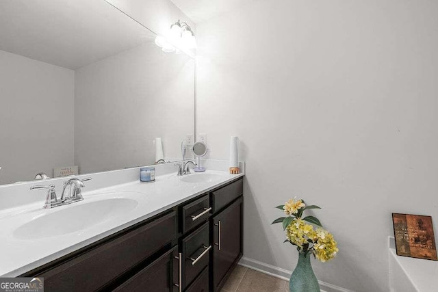 full bathroom featuring double vanity, tile patterned flooring, a sink, and baseboards