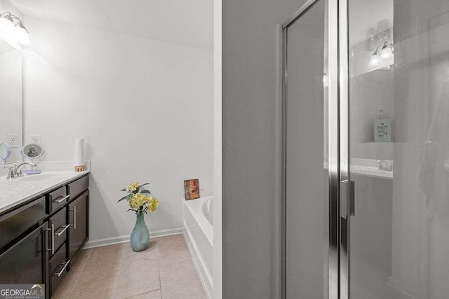 bathroom with a garden tub, vanity, baseboards, tile patterned floors, and an enclosed shower