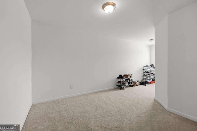 carpeted empty room featuring baseboards