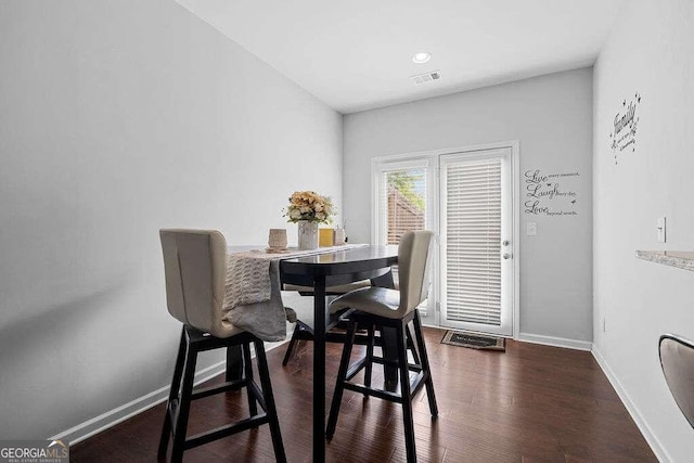 dining room with dark wood-style flooring, visible vents, and baseboards