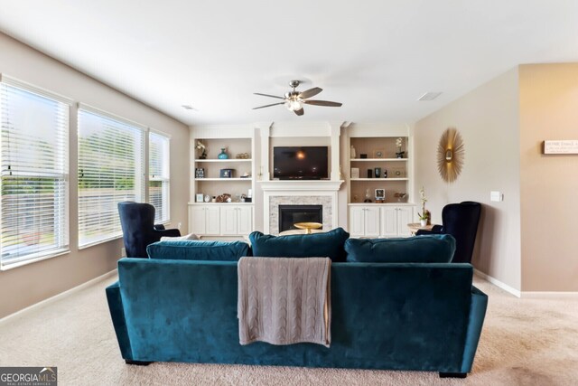 carpeted living room featuring built in features and ceiling fan