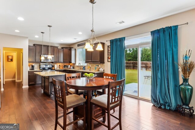 dining room featuring dark hardwood / wood-style floors, sink, and a notable chandelier