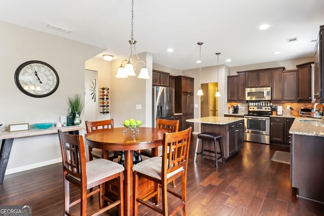 dining room featuring sink, a notable chandelier, and dark hardwood / wood-style floors