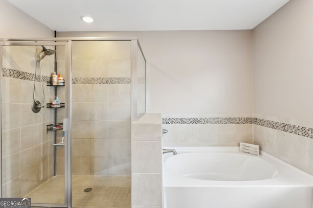 bathroom featuring shower with separate bathtub