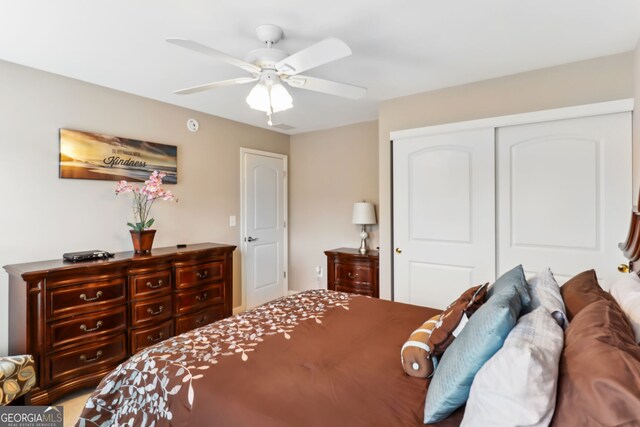 bedroom with a closet, ceiling fan, and light colored carpet