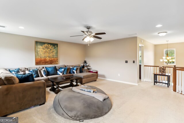 living room with ceiling fan with notable chandelier and carpet flooring