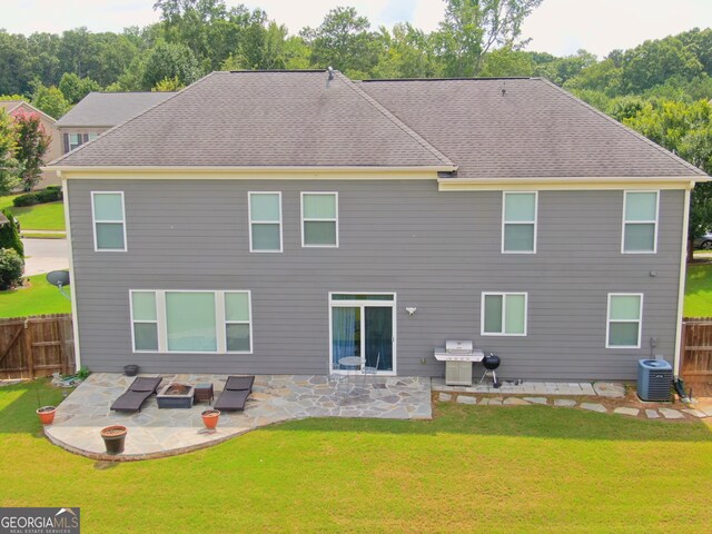 back of house featuring central air condition unit, a lawn, and a patio