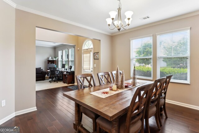 dining area featuring ornamental molding, a notable chandelier, and dark hardwood / wood-style flooring