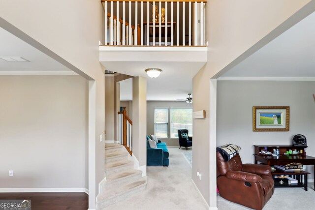 carpeted entryway with crown molding