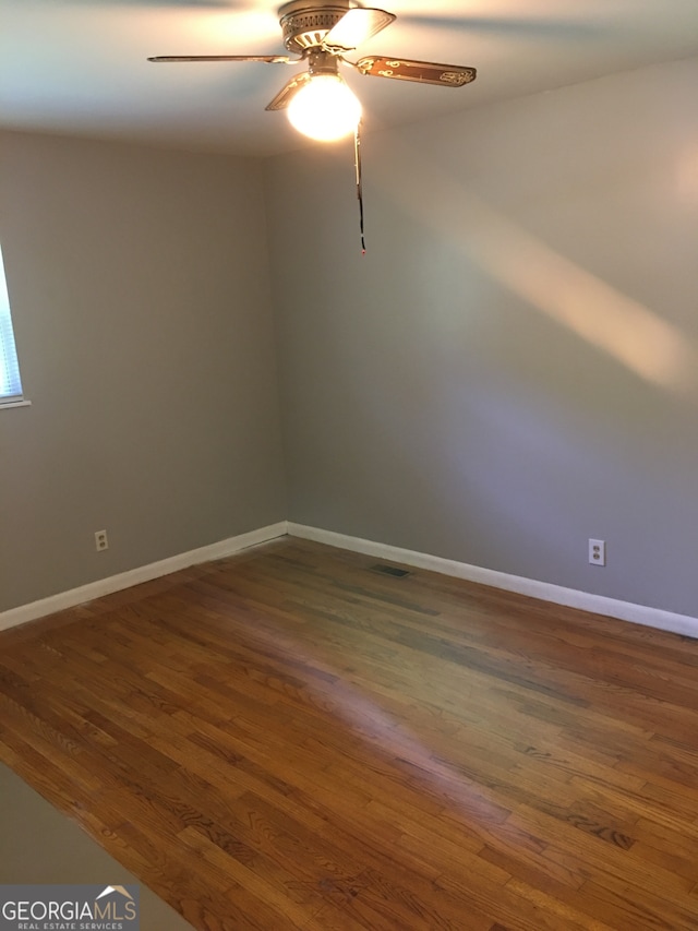 spare room featuring ceiling fan and dark hardwood / wood-style floors