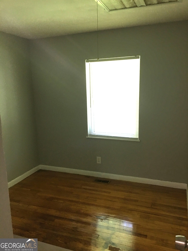 unfurnished room with dark hardwood / wood-style flooring