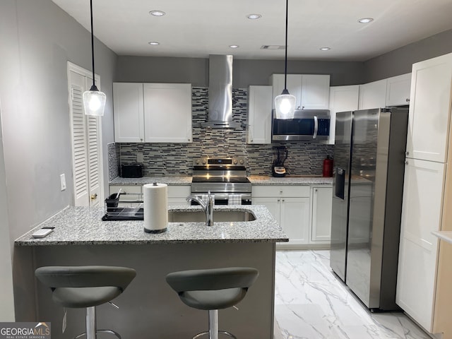 kitchen with light stone countertops, stainless steel appliances, wall chimney exhaust hood, and white cabinetry