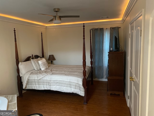 bedroom with dark wood-type flooring, ornamental molding, and ceiling fan