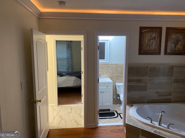 bathroom featuring toilet, wood-type flooring, crown molding, sink, and a relaxing tiled tub