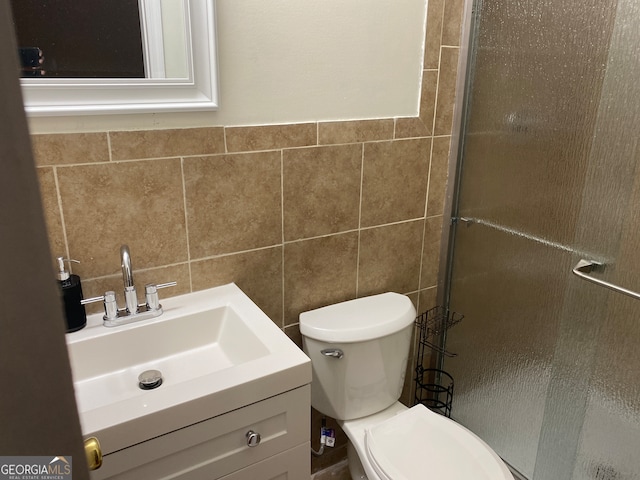 bathroom with walk in shower, vanity, tile walls, and toilet