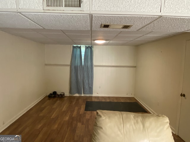 unfurnished room featuring a paneled ceiling and dark hardwood / wood-style flooring