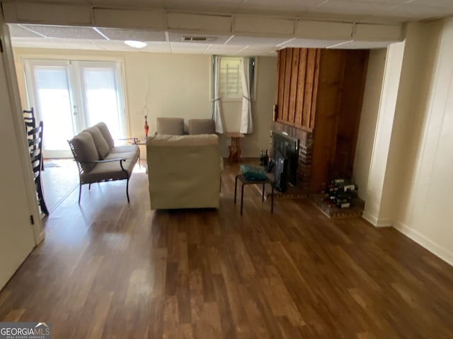 sitting room with a brick fireplace and dark hardwood / wood-style flooring