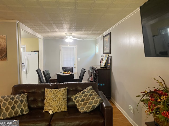 living room featuring wood-type flooring, ornamental molding, and ceiling fan