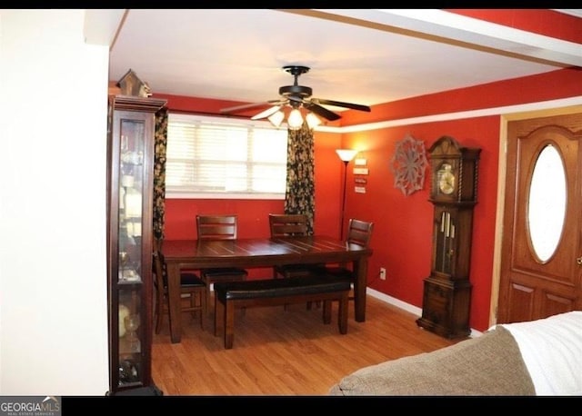 dining area with wood finished floors, a ceiling fan, and baseboards