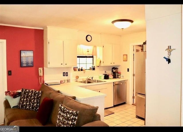 kitchen featuring a sink, white cabinetry, light countertops, stainless steel dishwasher, and freestanding refrigerator