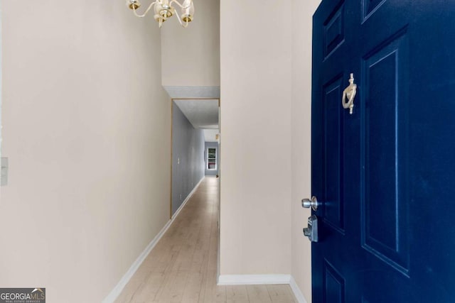 entrance foyer with light hardwood / wood-style floors and a notable chandelier