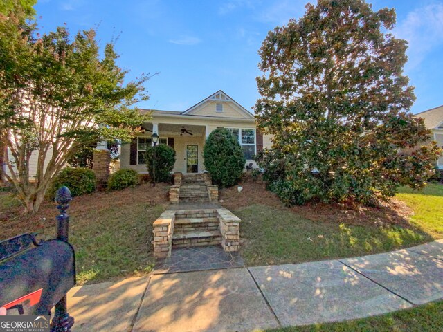 view of front facade featuring ceiling fan and a front lawn