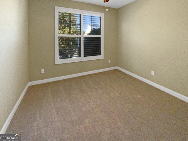 spare room featuring ceiling fan, carpet, and baseboards