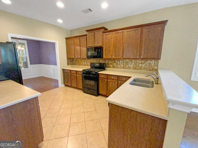 kitchen with decorative backsplash, sink, black appliances, kitchen peninsula, and light tile patterned flooring