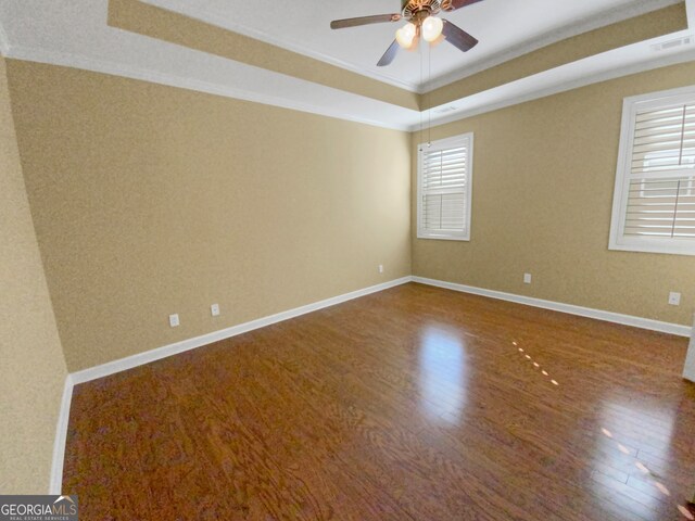 spare room featuring ceiling fan, a raised ceiling, crown molding, and hardwood / wood-style flooring