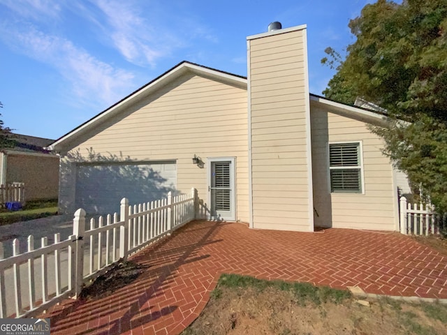 back of property with a chimney and fence