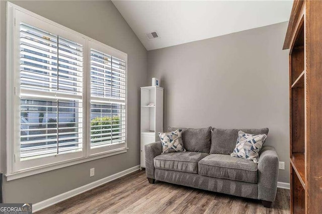 living area featuring hardwood / wood-style flooring and lofted ceiling