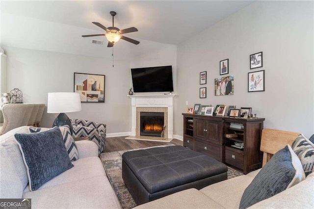 living room with ceiling fan, wood-type flooring, and a fireplace