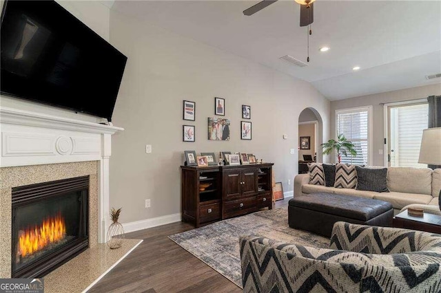 living room featuring ceiling fan, dark hardwood / wood-style floors, and vaulted ceiling