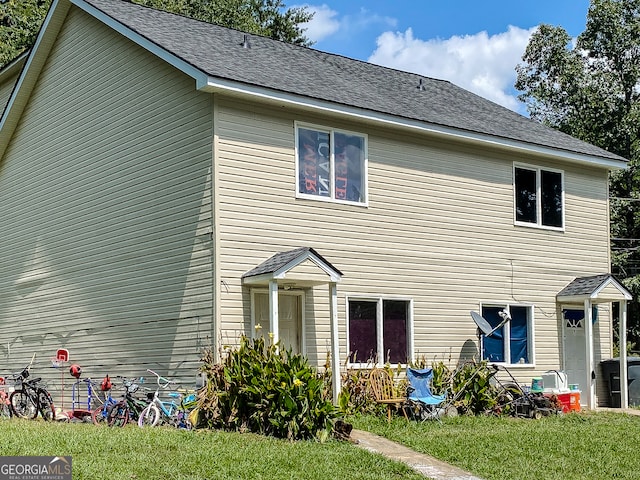 back of property featuring a lawn