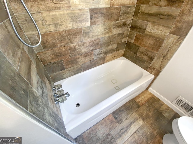 full bath featuring toilet, visible vents, and bathing tub / shower combination