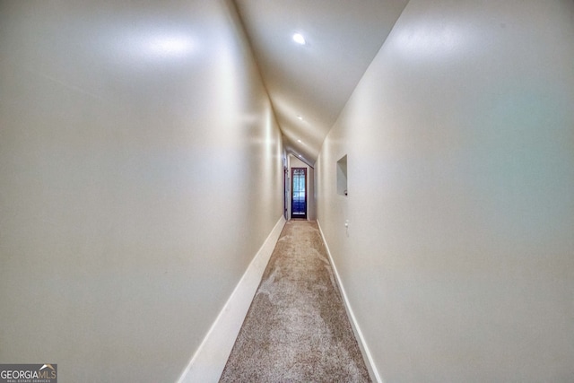 corridor featuring lofted ceiling and carpet floors