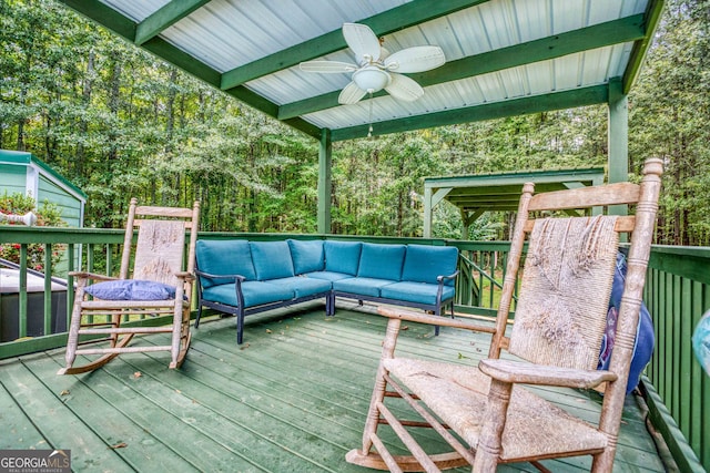 wooden deck with ceiling fan and outdoor lounge area