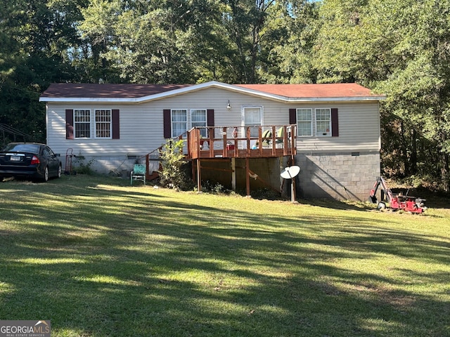 manufactured / mobile home featuring a front yard and a wooden deck