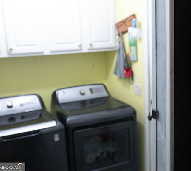 washroom featuring cabinets and separate washer and dryer