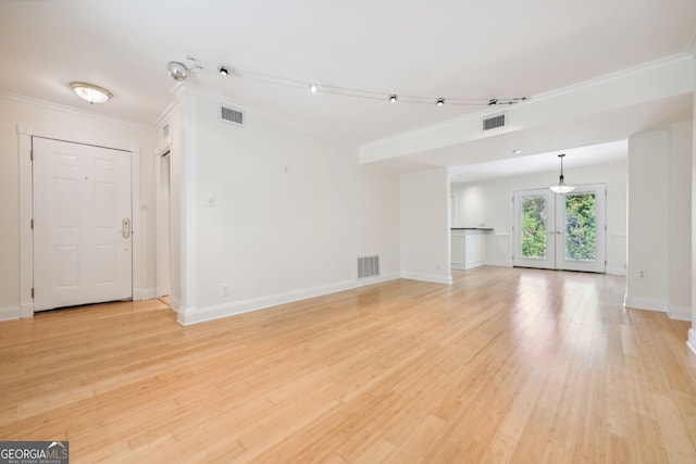 unfurnished living room with baseboards, visible vents, crown molding, and light wood finished floors