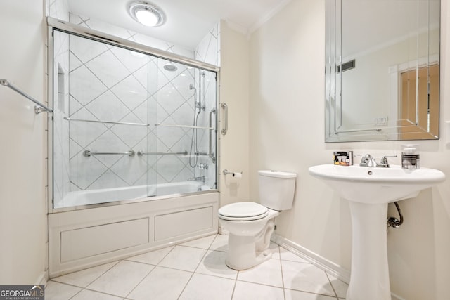 full bathroom with bath / shower combo with glass door, baseboards, toilet, ornamental molding, and tile patterned flooring